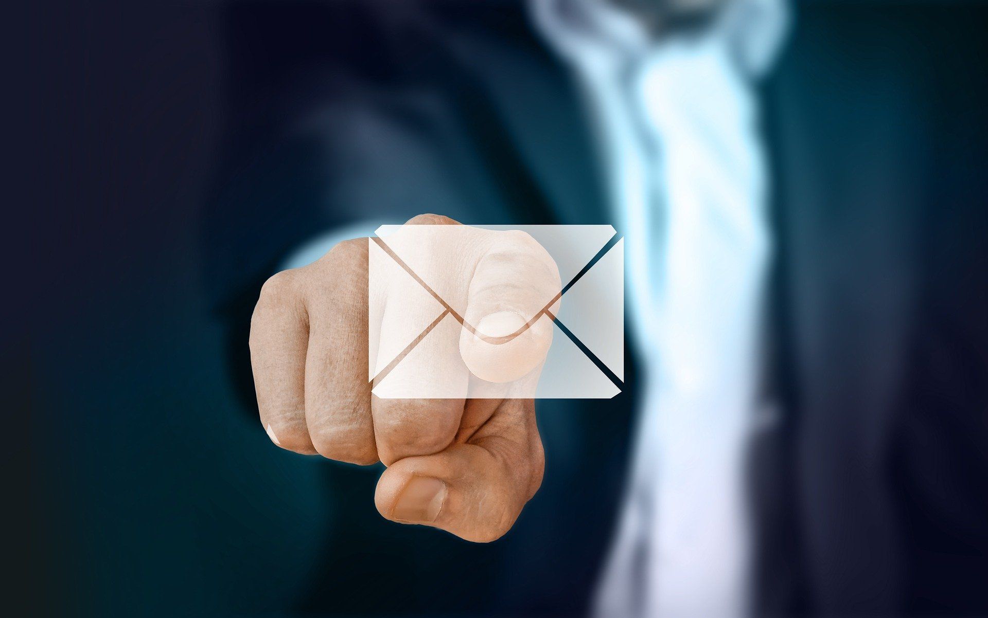 Businessmann tippt mit Zeigefinger auf einen Briefumschlag, der eine E-Mail symbolisiert als Zeichen für E-Mail Archivierung